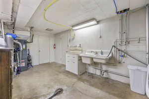 Below grade area with heating unit and a sink