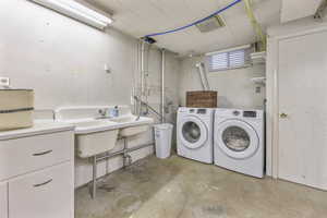 Laundry room with concrete floors and washer and clothes dryer
