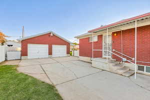View of front facade with an outbuilding, brick siding, and a garage