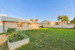 Fenced backyard featuring a vegetable garden