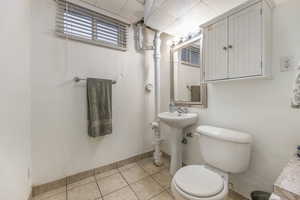 Half bath featuring toilet and light tile patterned floors