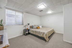 Bedroom featuring carpet and baseboards
