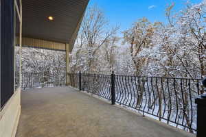 View of snow covered back of property from the upper level balcony