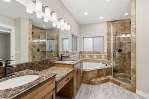 Primary bathroom featuring a shower stall, a garden tub, double vanity, and light wood-type flooring