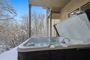 Snow covered patio with a hot tub