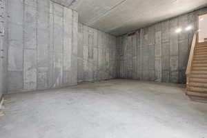 Unfinished below grade oversized garage/men's cave or workroom area with access to the house and back yard.