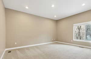 Guest room featuring light colored carpet and recessed lighting.  Beautiful view of the secluded back yard.