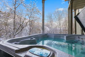 View of pool with a hot tub and a balcony