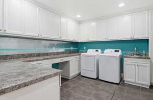 Second basement laundry room with washing machine and dryer, dark tile patterned floors, and recessed lighting