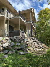 View of side of home featuring a balcony and stucco siding