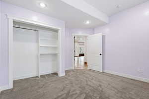 Unfurnished bedroom featuring light carpet, a closet, and recessed lighting