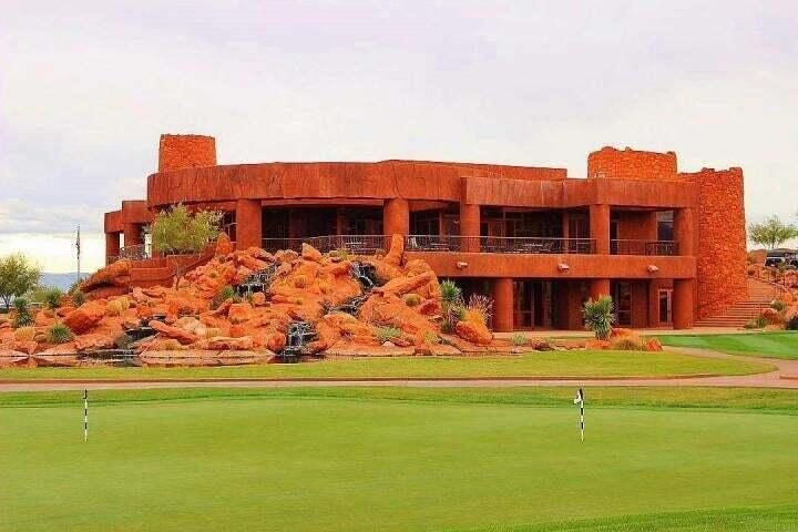 Surrounding community with a putting green, view of golf course, a yard, and a balcony