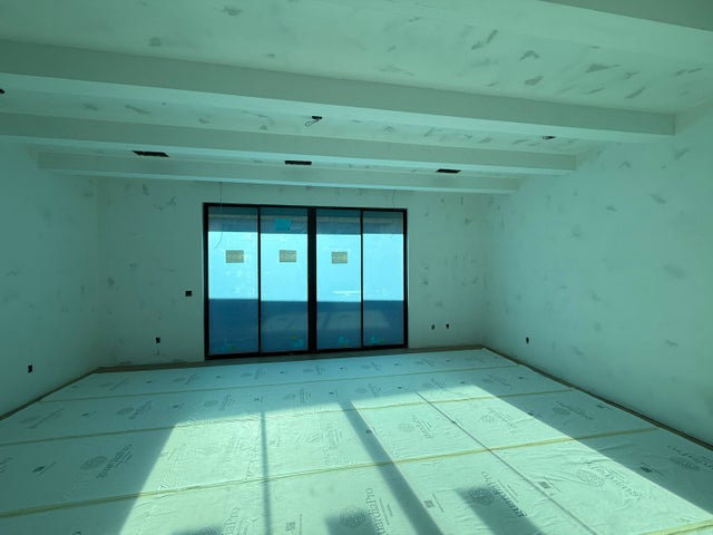 Empty room with beamed ceiling