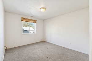 Spare room featuring carpet floors and a textured ceiling
