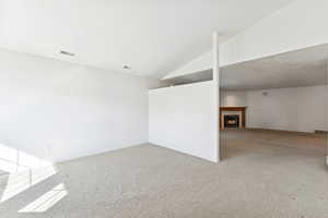 Entrance foyer with vaulted ceiling and light carpet