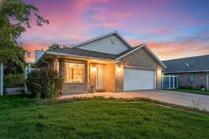 Single story home featuring concrete driveway, brick siding, a garage, and a shingled roof