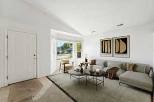 Living room with lofted ceiling and light tile patterned floors