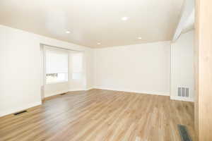 Empty room featuring light wood-style floors and recessed lighting