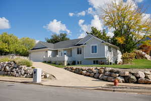 Single story home with brick siding, driveway, board and batten siding, and a garage