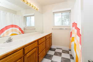 Bathroom with double vanity and a shower with curtain
