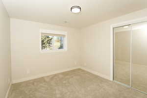 Unfurnished bedroom with carpet flooring and a closet