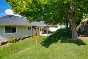 Back of house featuring a shingled roof and a patio area