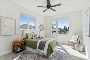 Carpeted bedroom with multiple windows, a ceiling fan, and recessed lighting