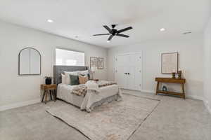 Carpeted bedroom featuring ceiling fan, recessed lighting, and a closet