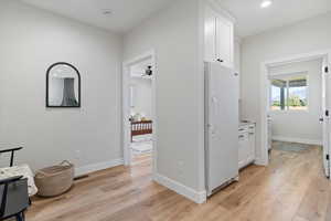 Corridor with light wood-style flooring and recessed lighting