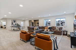 Living area with light colored carpet and recessed lighting