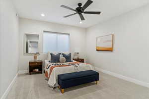 Carpeted bedroom with a ceiling fan and recessed lighting