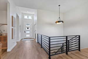 Foyer entrance featuring light wood-style flooring and a towering ceiling