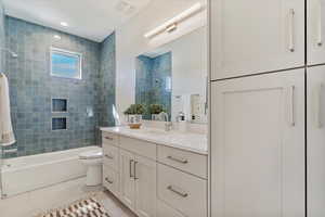 Bathroom featuring vanity, shower / bathtub combination, and light tile patterned floors