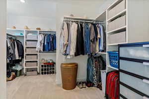 Walk in closet featuring light carpet