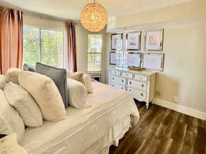 Bedroom with a textured ceiling and dark wood-type flooring