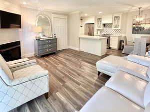 Living area with a fireplace, dark wood-type flooring, a chandelier, recessed lighting, and a textured ceiling