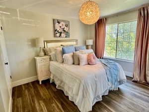 Bedroom with a textured ceiling and dark wood-style flooring