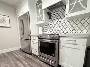 Kitchen featuring white cabinetry, tasteful backsplash, and appliances with stainless steel finishes