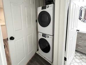 Washroom featuring stacked washer and clothes dryer and wood finished floors