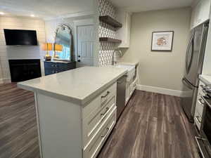 Kitchen with a peninsula, recessed lighting, white cabinetry, open shelves, and appliances with stainless steel finishes