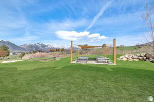 View of grassy yard with a patio and a mountain view