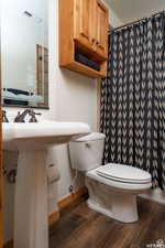 Bathroom with dark wood-style flooring, a shower with shower curtain, and a textured ceiling