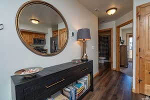 Hall featuring dark wood finished floors and a textured ceiling