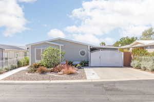View of front of house with a gate and concrete driveway