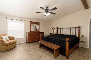 Bedroom with lofted ceiling, light wood finished floors, and a ceiling fan