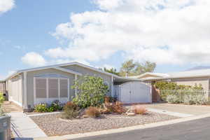 View of front of property featuring a gate and concrete driveway