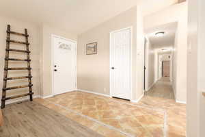 Foyer entrance with light tile patterned flooring and inlaid floor details