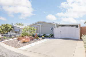 View of front of home with a fenced front yard, a gate, and driveway