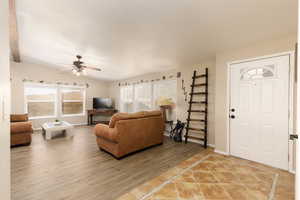 Living room featuring light wood-type flooring and a ceiling fan