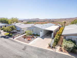 View of front of home with driveway, a mountain view, and an attached carport